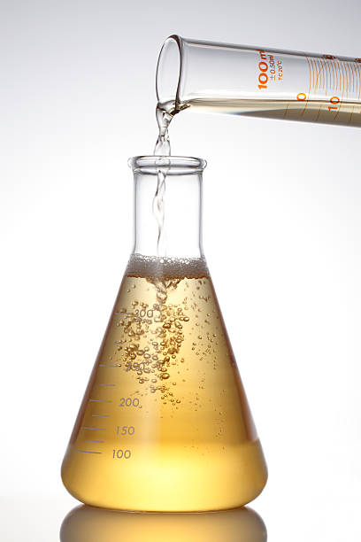 Lab Flask and Pouring Liquid. Lab Flask and Pouring Liquid. beaker photos stock pictures, royalty-free photos & images