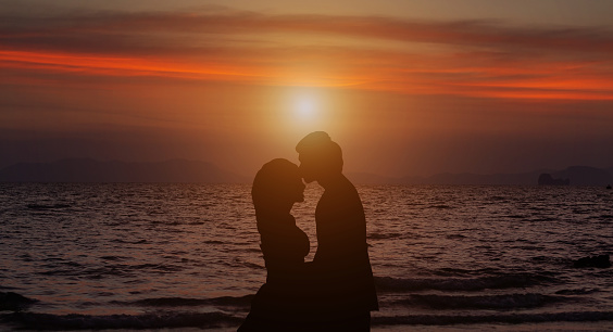 silhouette of a couple in the beautiful sunset on the sea background
