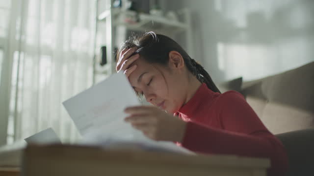 Asian Woman stressed about debt