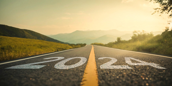 A picturesque road with ‘2024’ prominently displayed, set against a backdrop of majestic mountains and a breathtaking sunrise. This image encapsulates the spirit of the New Year 2024, symbolizing change, fresh starts, and the excitement of embarking on a new journey.