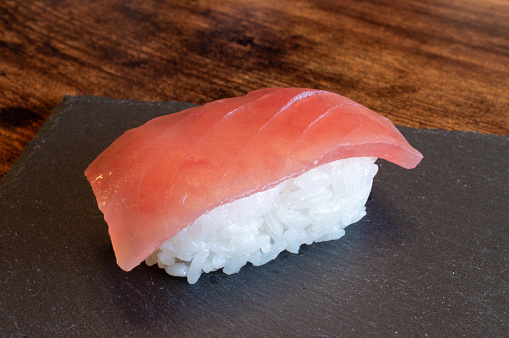 Japanese raw food delicacies in decorated serving dish full of ice, nigiri, tataki, prawn and tuna slices with ginger and wasabi