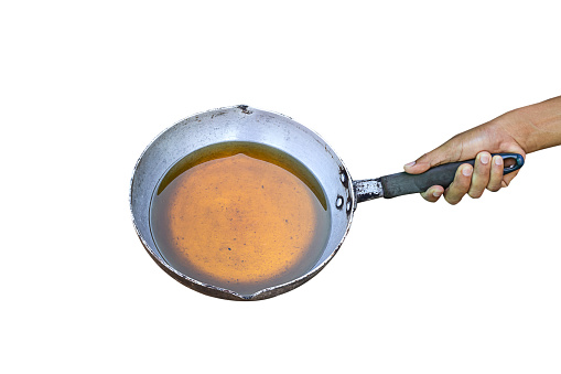 Man holds a pan of old vegetable oil or used vegetable oil. Isolated on white background.