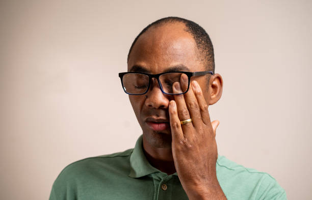 istock Man scratches his eye under his glasses on a pastel background. 1789451798