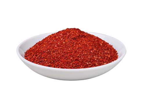 dry red pepper flake powder coarse isolated. Korean chili ground Gochugaru. Korean red pepper flake powder coarse ground gochugaru in white bowl isolated