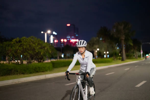 밤에 도로 자전거를 타는 아시아 여성 - mental health women asian ethnicity bicycle 뉴스 사진 이미지