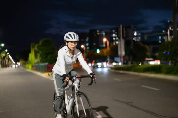 azjatka jadąca nocą na rowerze szosowym - mental health women asian ethnicity bicycle zdjęcia i obrazy z banku zdjęć