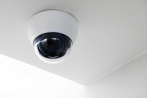 Modern public CCTV camera on ceiling with copy space.