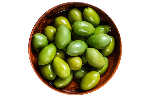 Marinated Green big olives in wooden bowl with oil.  Isolated, white background. Top view