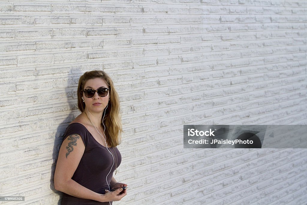 Niña contra la pared de ladrillo blanco - Foto de stock de Adulto libre de derechos