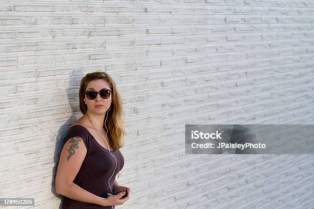 Niña Contra La Pared De Ladrillo Blanco Foto de stock y más banco de imágenes de Adulto - Adulto, Adulto joven, Apoyarse