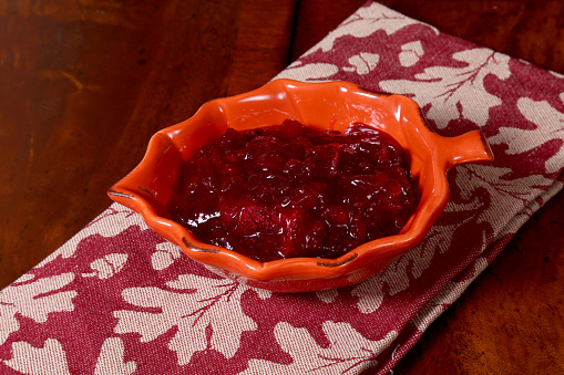 Fresh red cranberries in a glass bowl on white background