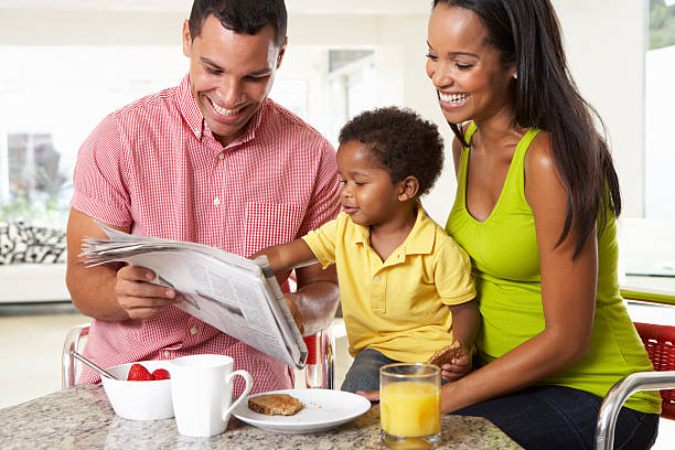 família tomando café da manhã em cozinha juntos - reading newspaper 30s adult - fotografias e filmes do acervo