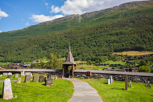Lom, Norway, June 25, 2023: The Lom Stave Church is one of the largest and oldest stave churches in Norway, built in the mid-12th century. Here is the graveyard that surrounds the chapel.