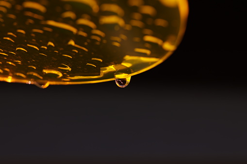 yellow plexiglass disc with raindrops and dark background