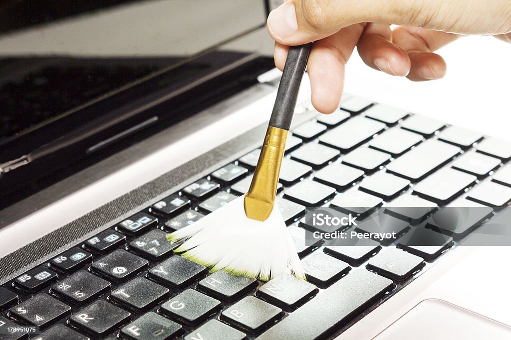 Cleaning computer. Cleaning laptop keyboard by brush. Cleaning Stock Photo