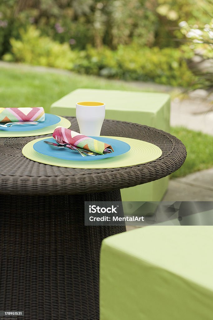 Garden Table Backyard setting with wicker table and tablesetting. Cup Stock Photo