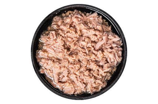 Canned tuna fish with oil in a pan. Isolated, white background. Top view