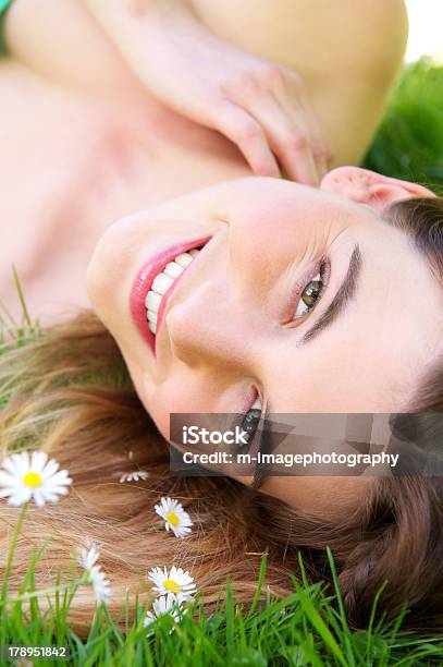 Foto de Caucasiana Jovem Mulher Sorridente Ao Ar Livre Com Flores e mais fotos de stock de Deitar