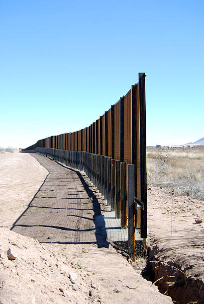 US-Mexico border fence close-up "Vertical close-up of Border fence under construction in Arizona (US to the left, Mexico to the right)." international border barrier stock pictures, royalty-free photos & images