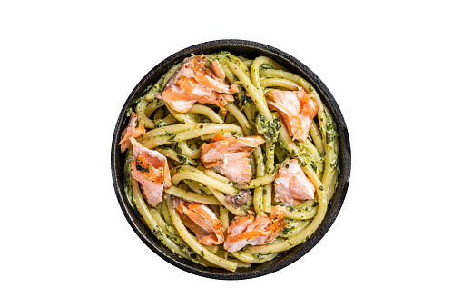Salmon Bucatini pasta with creamy spinach sauce and fish fillet.  Isolated, white background. Top view