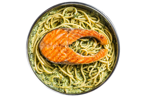 Florentine pasta with creamy spinach sauce and grilled salmon steak. Isolated, white background. Top view