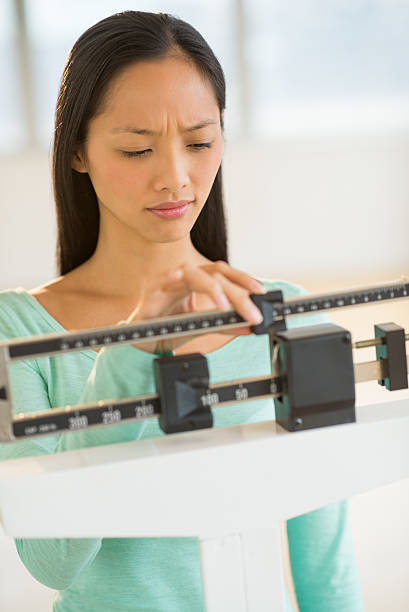 istock Woman Adjusting Balance Weight Scale 178955103
