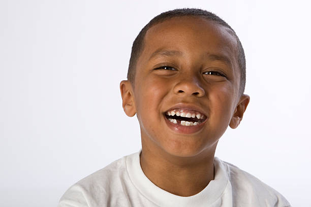 Portrait of laughing boy of mixed races Smiling boy of mixed ethnicity is african american, caucasion and native american. He is missing a bottom tooth. health symbols/metaphors stock pictures, royalty-free photos & images