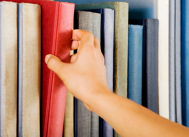 istock Woman reaching out to grab a book 178956575