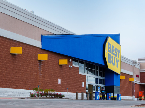 New Hartford, New York - Nov 11, 2023: Close-up Landscape View of Best Buy Store Entrance with Customer Leaving out.