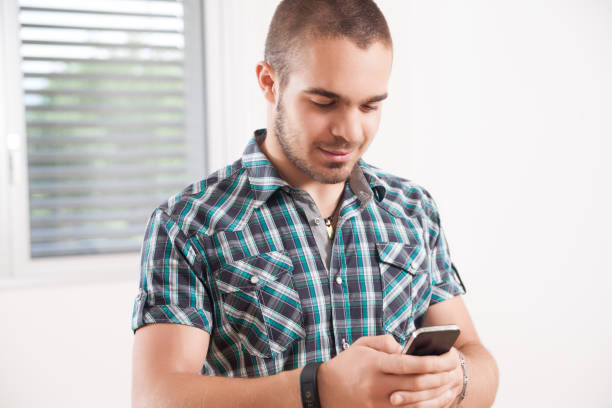 istock young short-haired man checks his smartphone smiling 1789569096