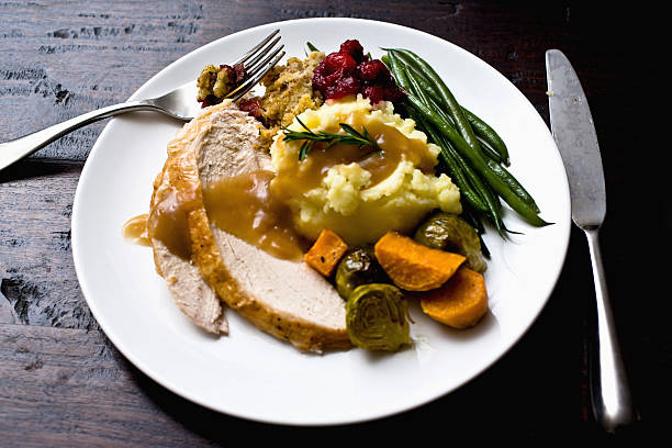 A plate of turkey, mashed potatoes, and vegetables stock photo