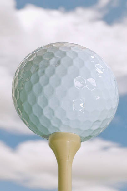 istock golf ball on tee against blue sky with puffy clouds 178957206