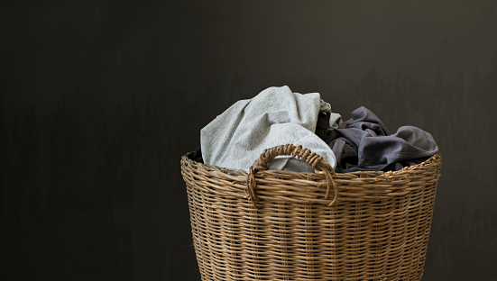 Used clothes are included in the basket on a dark gray background.