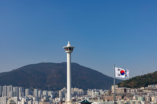 beautiful busan diamond tower with skyline and south korea flag in busan, south korea.