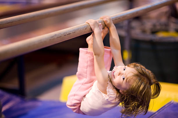 малыш на параллельные брусья - gymnastics стоковые фото и изображения