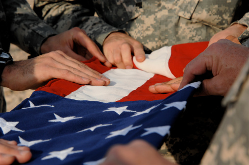 American Soldiers fold a flag during a memorial ceremony for a fallen comrade in Iraq.