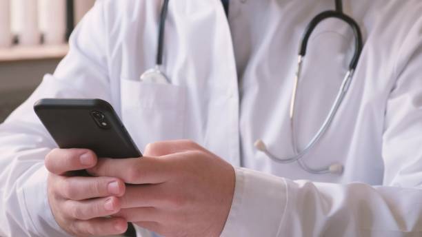 istock A doctor uses a smartphone to communicate with sick patients. Online treatment 1789630680