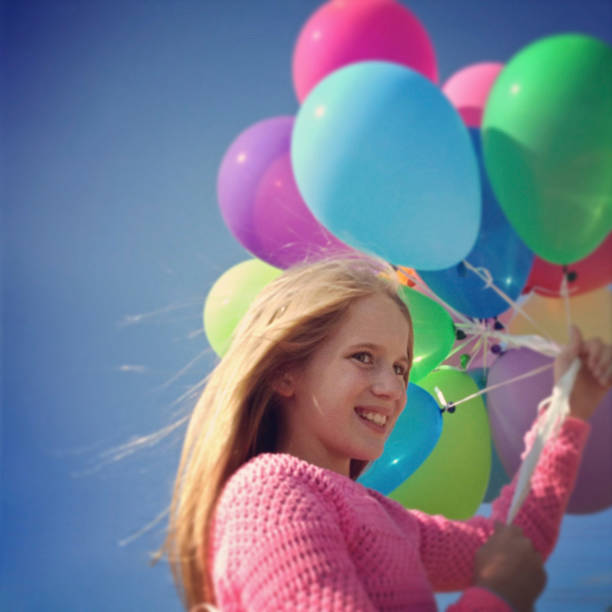istock Girl holding balloons 178963494