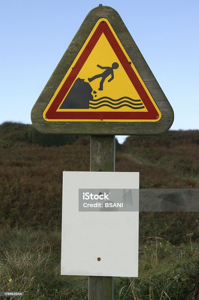 Warning sign Old warning sign. Drop to the sea Beach Stock Photo