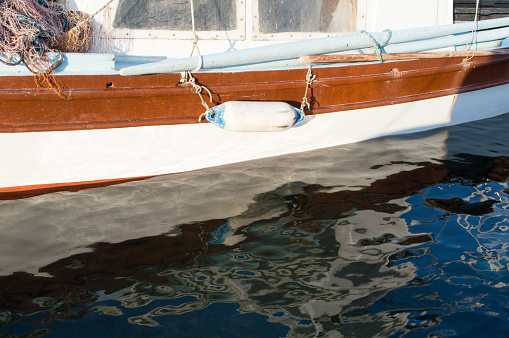 Old wooden fishing boat with reflection in the water, in Dalmatia, Croatia