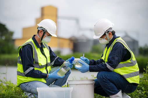 Saving earth. Environmental researchers investigate the condition of canal water for toxic spill, river waste water sampling, Scientist collect water samples for analysis and research on water quality