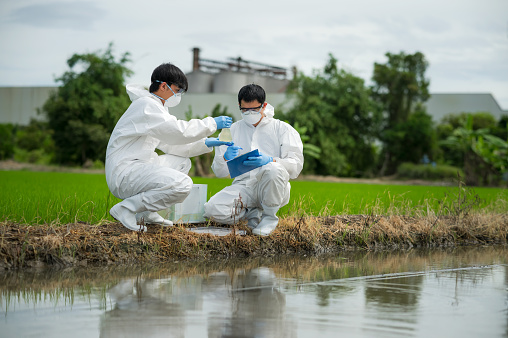Saving earth. Environmental researchers investigate the condition of canal water for toxic spill, river waste water sampling, Scientist collect water samples for analysis and research on water quality
