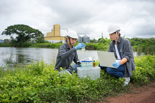 Saving earth. Environmental researchers investigate the condition of canal water for toxic spill, river waste water sampling, Scientist collect water samples for analysis and research on water quality