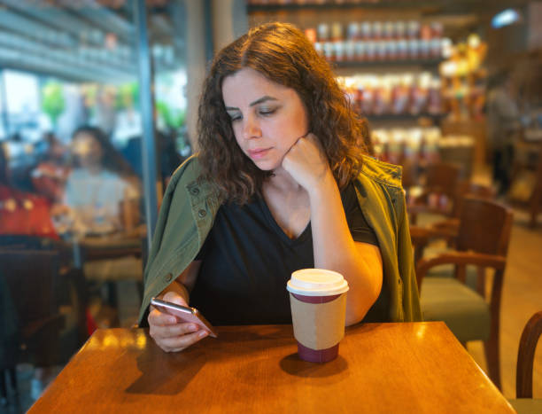 istock Beautiful woman using smartphone for financial work while drinking coffee in coffee shop. Vintage tone color. 1789674329