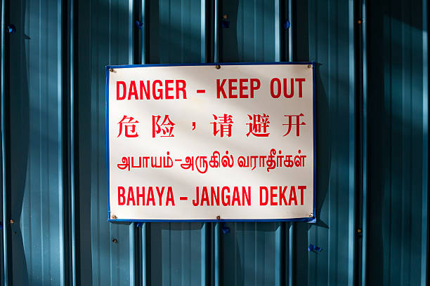 istock Danger keep out sign against blue metal in four languages 178967459