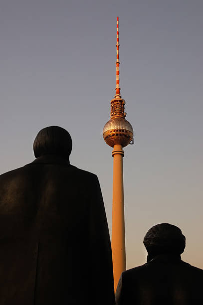 Marx and Engels states (under shadow) looking the Berlin TV Tower (Fernsehturm)