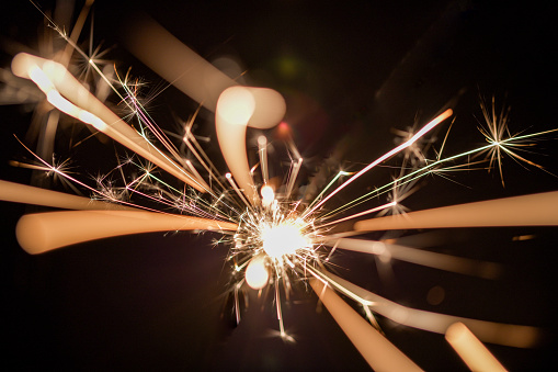An abstract slow shutter speed bird’s eye view of a sparking sparkler, symbolising speed, light, celebration