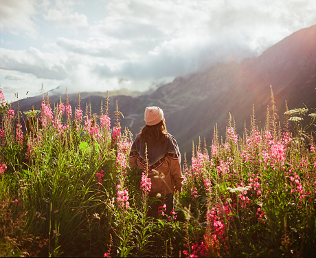 Serene woman  standing in  lupin flower field in the mountains