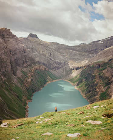 Woman in red raincoat hiking near Limmerensee lake in Swiss Alps. Shot on camera film