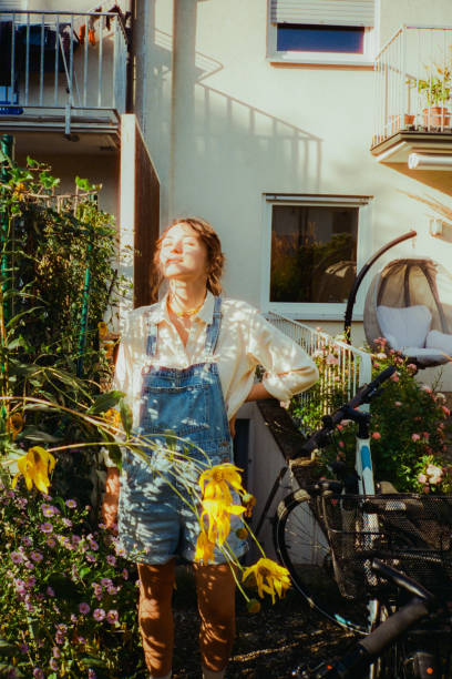 Woman enjoying sunshine on the backyard while getting out bicycle from the basement of her house. Shot on camera film